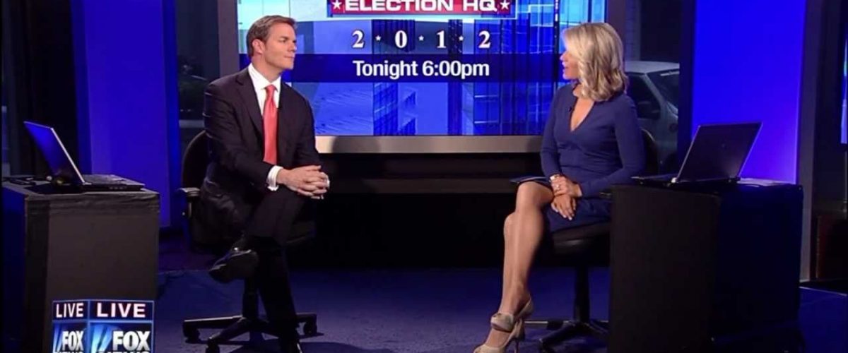 A group of people sitting at a desk in front of a computer screen