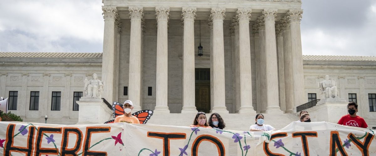 A group of people in front of United States Supreme Court Building